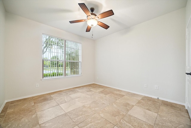 spare room featuring a ceiling fan and baseboards