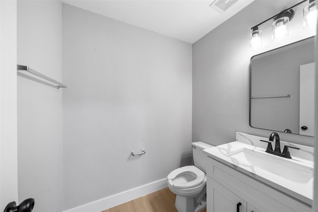 bathroom featuring wood-type flooring, vanity, and toilet