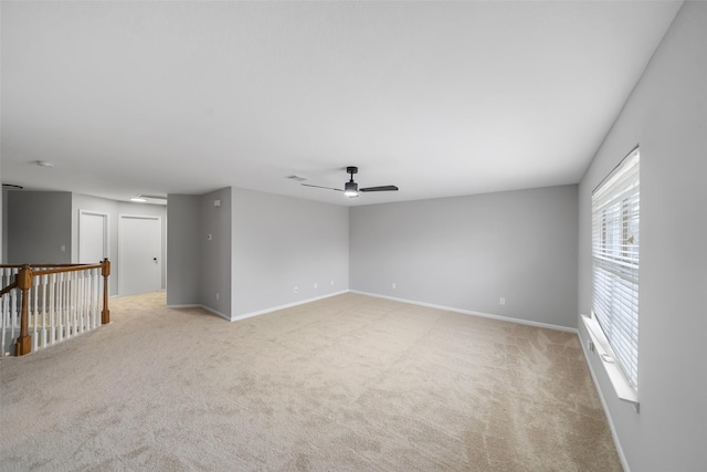 empty room featuring light colored carpet and ceiling fan