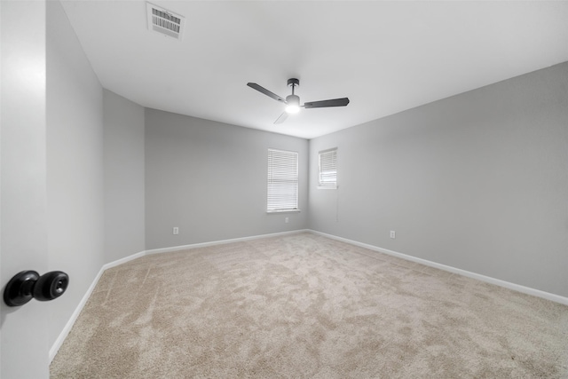 spare room featuring light carpet and ceiling fan