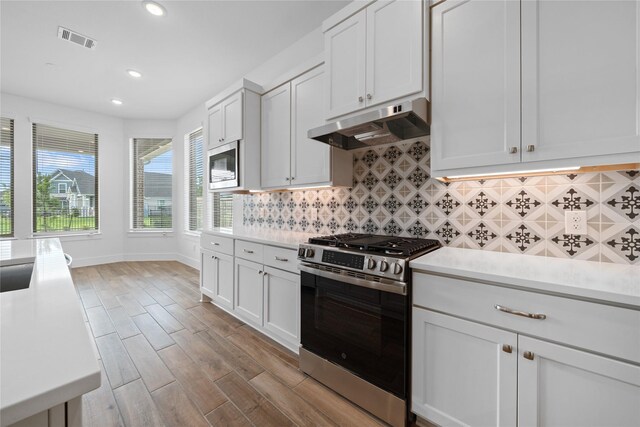 32646 Fly Fish Way, Fulshear, TX 77441 - kitchen featuring appliances with stainless steel finishes, under cabinet range hood, light countertops, light wood-type flooring, and recessed lighting