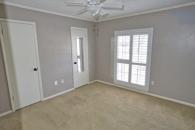 carpeted spare room with ornamental molding, ceiling fan, and a textured ceiling