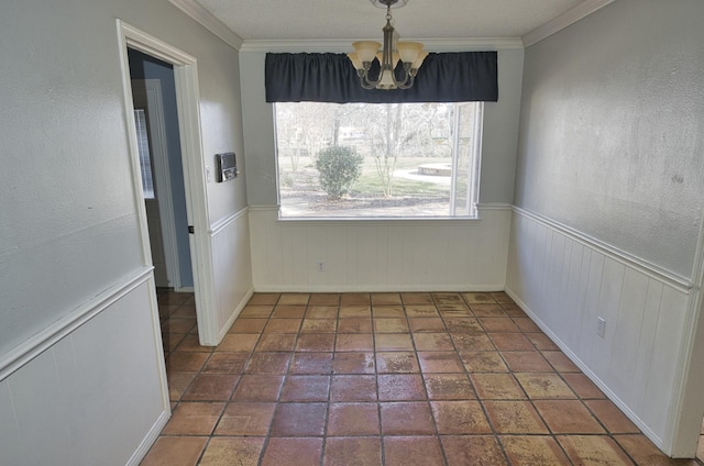 unfurnished dining area with crown molding and a notable chandelier