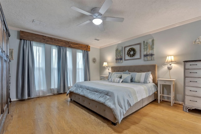 bedroom with ceiling fan, crown molding, light hardwood / wood-style flooring, and a textured ceiling