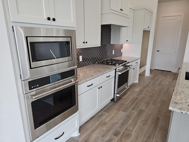 32650 Fly Fish Way, Fulshear, TX 77441 - kitchen featuring appliances with stainless steel finishes, wood finished floors, and white cabinets