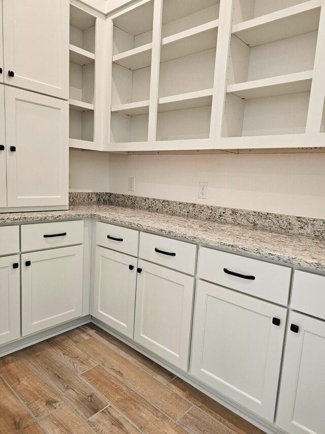 32650 Fly Fish Way, Fulshear, TX 77441 - kitchen featuring open shelves, light wood-style flooring, white cabinetry, and light stone countertops
