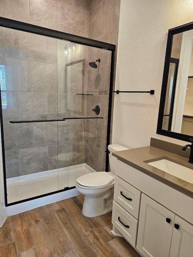 32650 Fly Fish Way, Fulshear, TX 77441 - bathroom featuring vanity, a stall shower, toilet, wood finished floors, and a textured wall