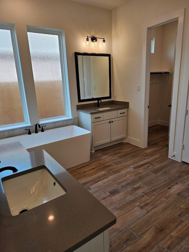 32650 Fly Fish Way, Fulshear, TX 77441 - full bath with a freestanding bath, wood finished floors, vanity, a walk in closet, and baseboards
