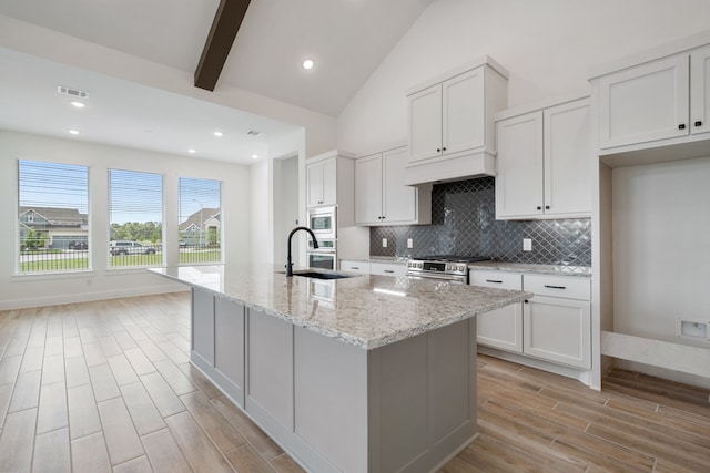 32650 Fly Fish Way, Fulshear, TX 77441 - kitchen featuring stainless steel appliances, light wood-style floors, white cabinetry, light stone countertops, and recessed lighting