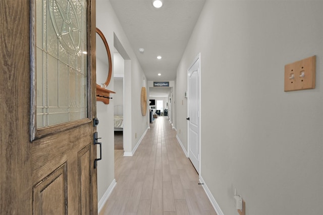 hall featuring a textured ceiling and light wood-type flooring