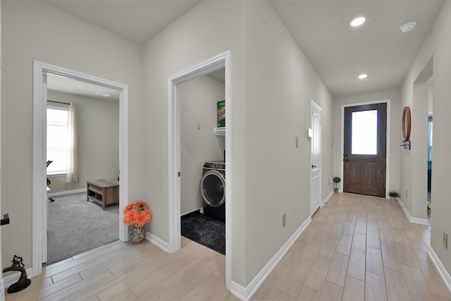 foyer featuring washer / clothes dryer, a wealth of natural light, and light wood-type flooring