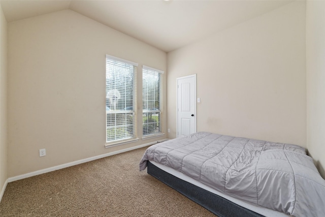 carpeted bedroom featuring vaulted ceiling and baseboards