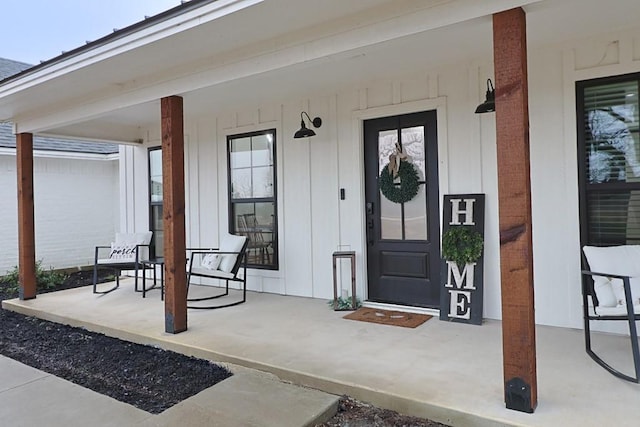 view of exterior entry featuring covered porch