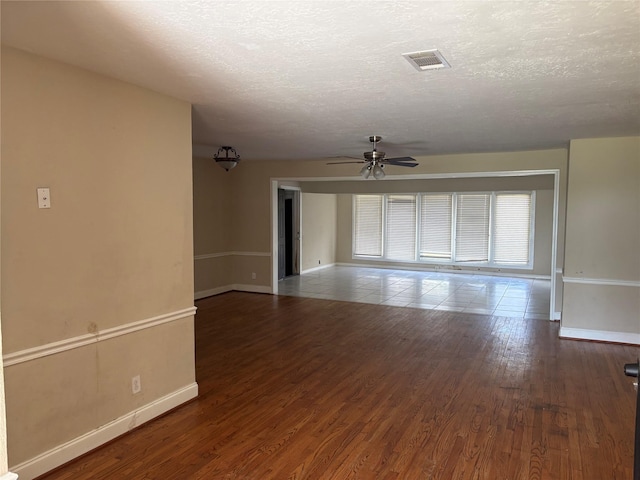 spare room featuring a textured ceiling, dark hardwood / wood-style floors, and ceiling fan