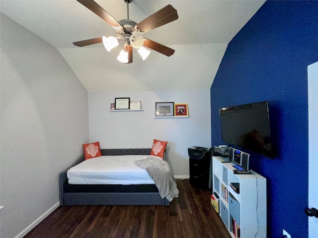 bedroom featuring dark wood finished floors, vaulted ceiling, baseboards, and ceiling fan