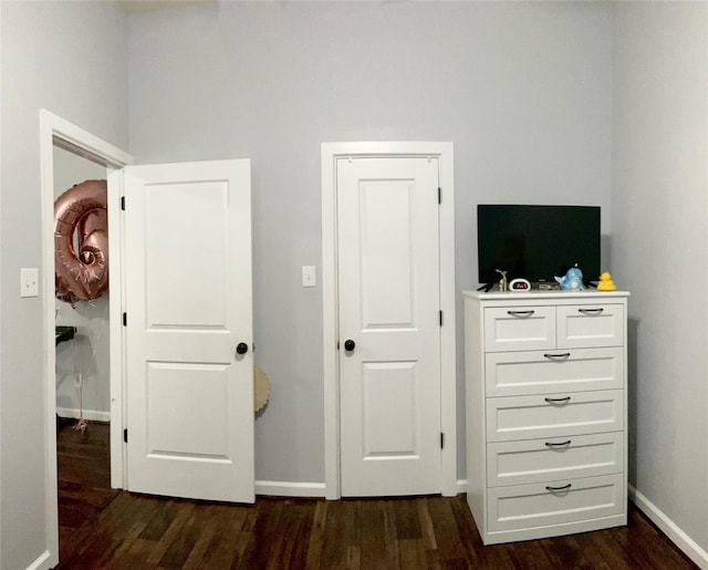 bedroom featuring dark wood-style floors and baseboards