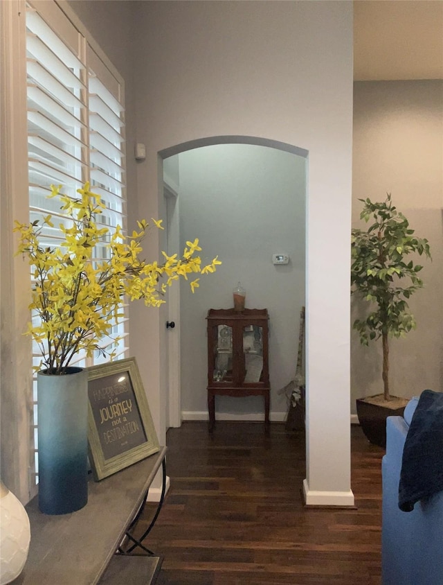 corridor with dark wood-style floors and baseboards