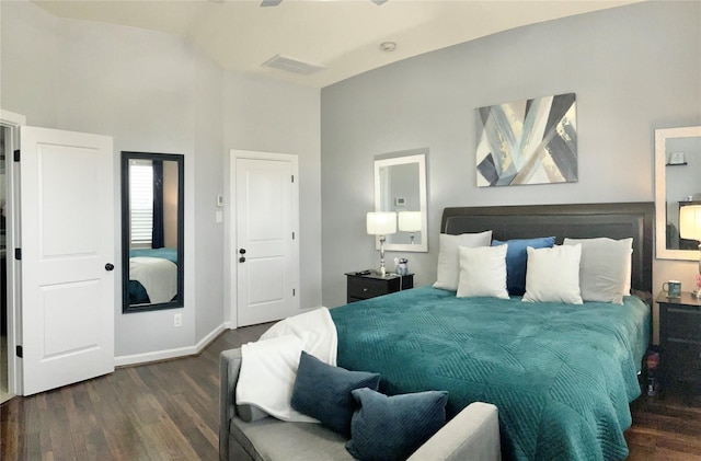 bedroom with lofted ceiling, visible vents, baseboards, and dark wood-style flooring