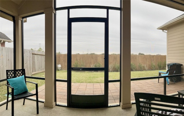 entryway featuring expansive windows, a sunroom, and plenty of natural light