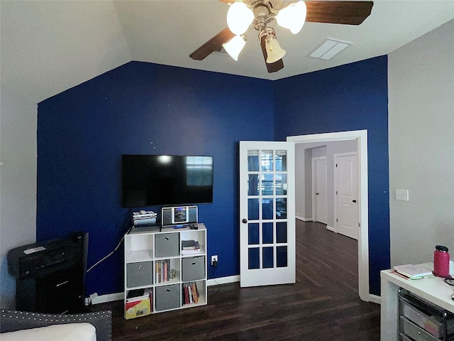 interior space with dark wood-style flooring, lofted ceiling, visible vents, a ceiling fan, and baseboards