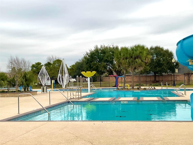 community pool featuring fence and a patio