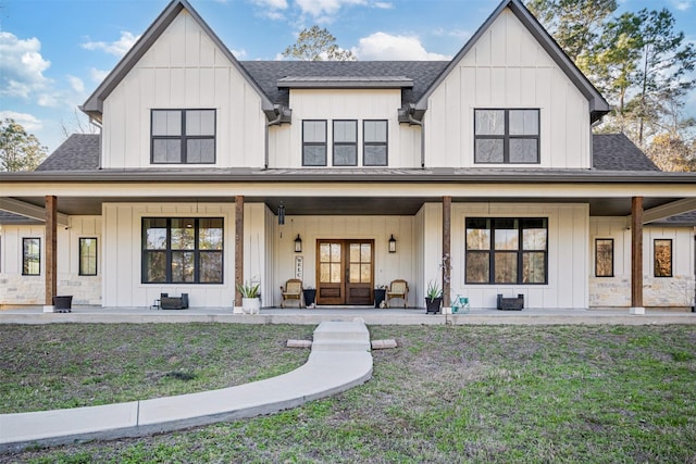 modern farmhouse style home featuring a porch, board and batten siding, and roof with shingles