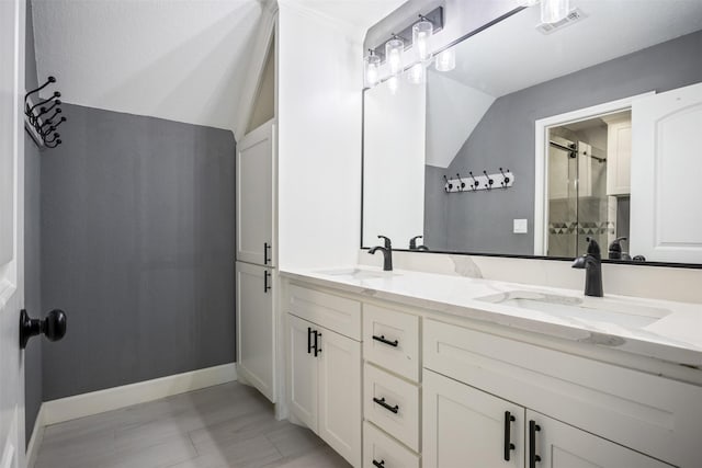 bathroom featuring a stall shower, visible vents, a sink, and lofted ceiling