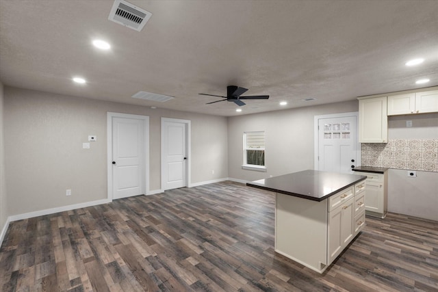 kitchen with white cabinetry, decorative backsplash, dark hardwood / wood-style flooring, and ceiling fan