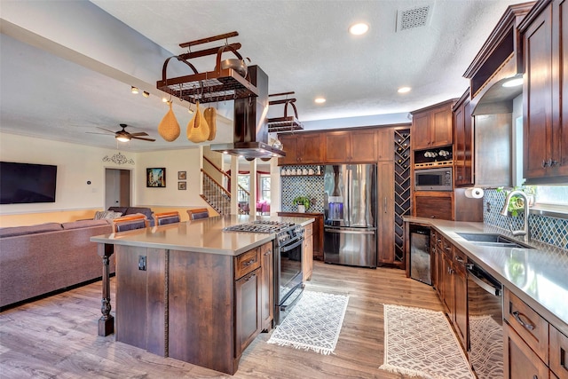 kitchen featuring appliances with stainless steel finishes, open floor plan, a breakfast bar area, a center island, and island exhaust hood