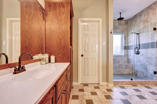 bathroom with a shower stall, baseboards, and vanity