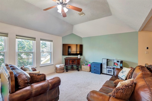 living room with lofted ceiling, a textured ceiling, visible vents, a ceiling fan, and carpet