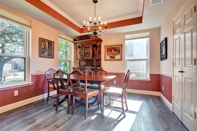 dining space featuring dark wood-style floors, a tray ceiling, visible vents, and a notable chandelier