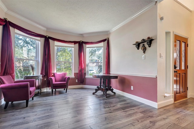 sitting room featuring a healthy amount of sunlight, crown molding, a textured ceiling, and wood finished floors