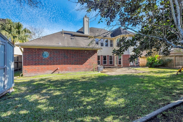 back of house featuring a patio area, brick siding, and a lawn