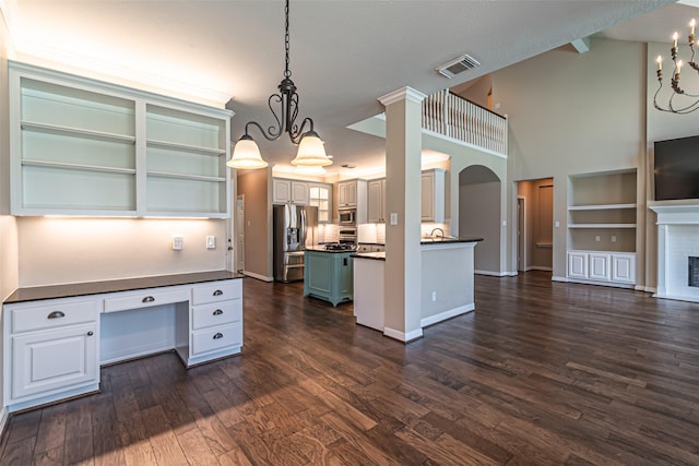 kitchen with pendant lighting, stainless steel appliances, dark countertops, visible vents, and white cabinets