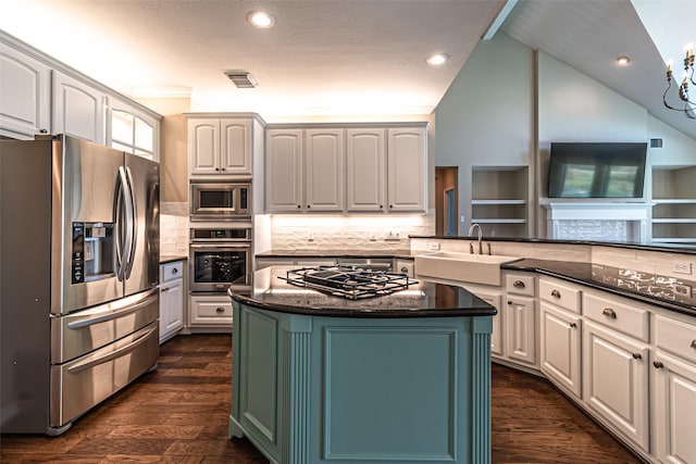 kitchen with white cabinetry, stainless steel appliances, a sink, and a center island