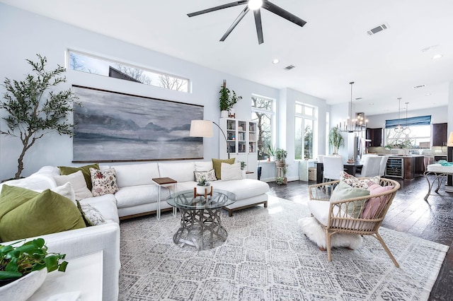 living area featuring recessed lighting, visible vents, hardwood / wood-style floors, and ceiling fan with notable chandelier