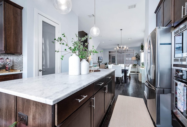 kitchen with a center island, visible vents, stainless steel appliances, and dark brown cabinetry
