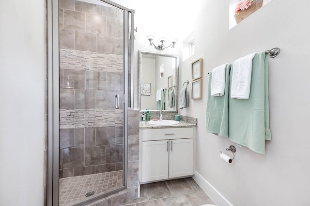 bathroom with baseboards, a stall shower, and vanity
