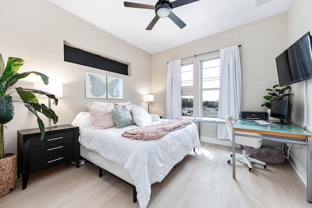 bedroom with ceiling fan, baseboards, and light wood-type flooring