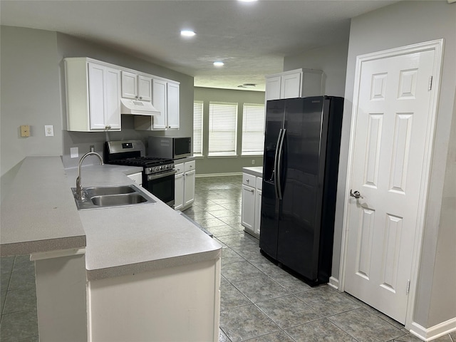 kitchen featuring white cabinets, appliances with stainless steel finishes, sink, and kitchen peninsula