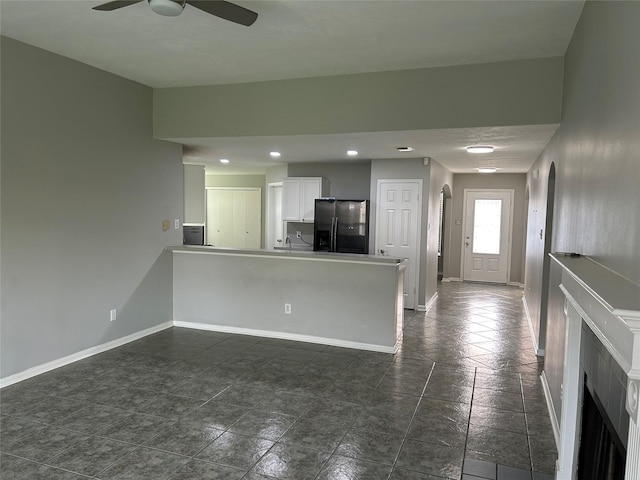 kitchen featuring white cabinets, ceiling fan, stainless steel fridge, and kitchen peninsula