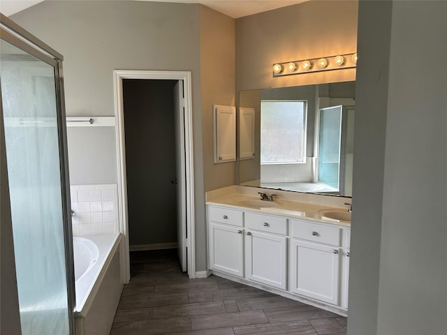 bathroom with vanity and tiled bath