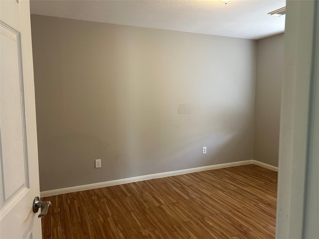 unfurnished room with hardwood / wood-style flooring