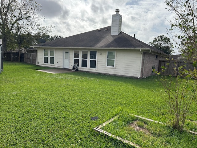 back of house featuring a lawn and a patio area