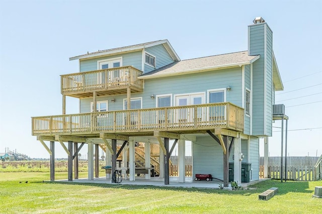 rear view of house with a yard, a patio area, a balcony, and a deck