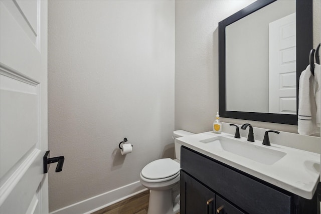 bathroom featuring toilet, hardwood / wood-style flooring, and vanity