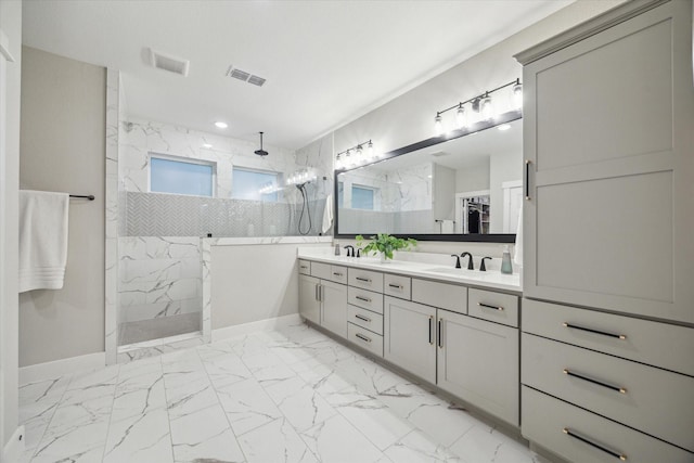 bathroom featuring tiled shower and vanity