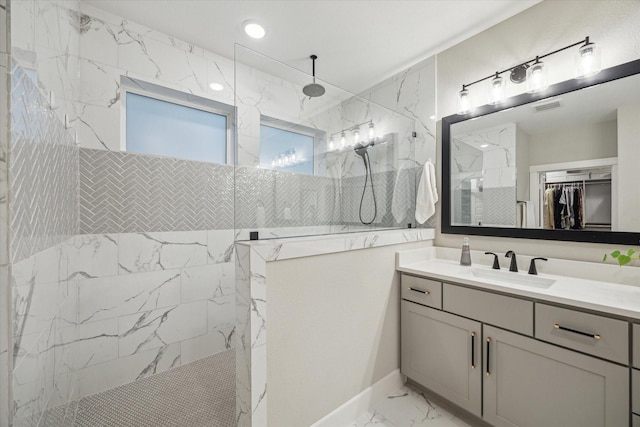 bathroom featuring tiled shower and vanity