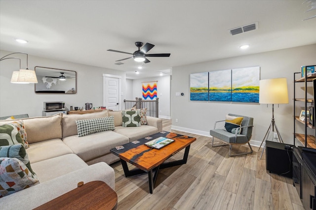 living room featuring ceiling fan and light wood-type flooring